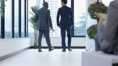 4 k kurumsal iş adamları konuşuyor ve şehir ofis binası içinde el sallayarak