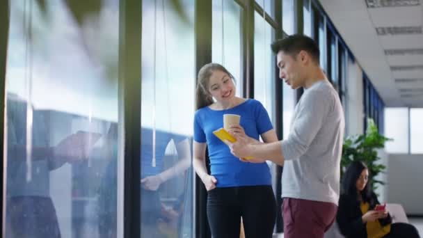 4K femme d'affaires caucasienne regardant la vue de la fenêtre et discutant du travail avec un collègue masculin 
