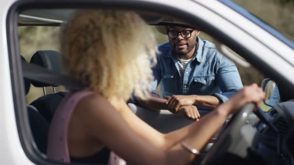 彼女の車の開いている窓から若い女性にチャット 流行に敏感な男 — ストック動画