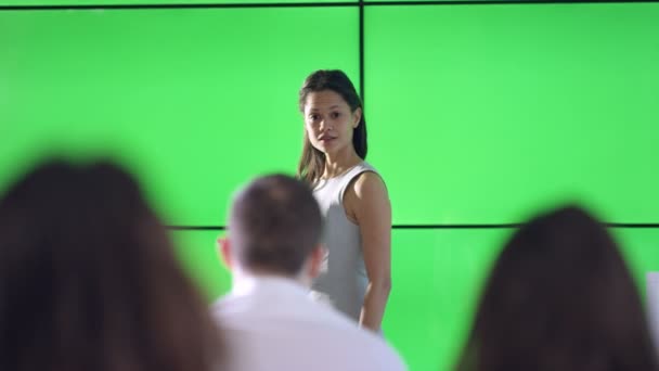 若い実業家のプレゼンテーションを与えると緑色の画面のビデオ壁との相互作用 — ストック動画