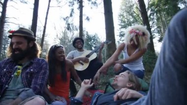 Ormanda kamp, gitar çalıyor ve şarkı 4 k mutlu hipster arkadaşlar