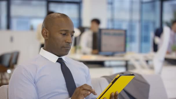非洲裔美国商人使用平板电脑在办公室 同事带来的文件 — 图库视频影像