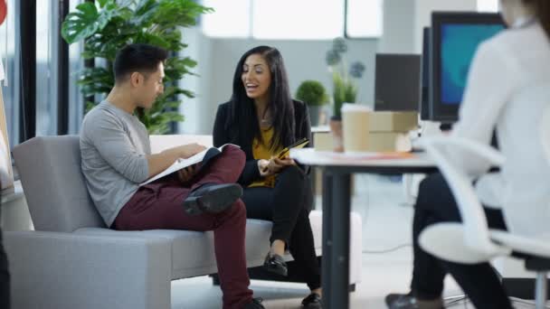 4K Groupe d'affaires occasionnel travaillant et discutant des idées dans le bureau créatif moderne 