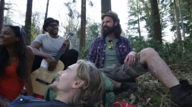 4 k mutlu hipsters ormanda, bir adam bir hikaye onun arkadaşlarına söylüyor kamp