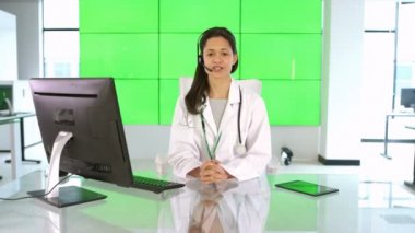 Müşteri veya hasta için yeşil arka plan üzerinde konuşurken 4 k mutlu tıbbi hizmet danışmanı