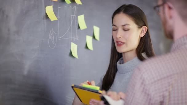 Giovane Uomo Donna Discussione Brainstorming Con Note Appiccicose Sulla Lavagna — Video Stock