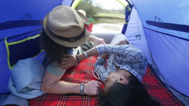 魅力的な流行に敏感なカップルのキャンプ旅行に彼らのテントで親密さを共有 — ストック動画