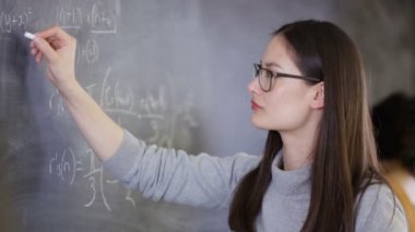 yazı tahtası üzerinde matematiksel Denklem yazma 4 k genç akıllı üniversite öğrencisi
