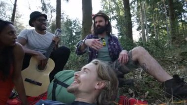 4 k mutlu hipsters ormanda, bir adam bir hikaye onun arkadaşlarına söylüyor kamp