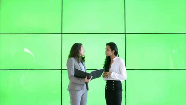 4k-Geschäftsfrauen im Gespräch in modernem Büro mit Greenscreen-Hintergrund