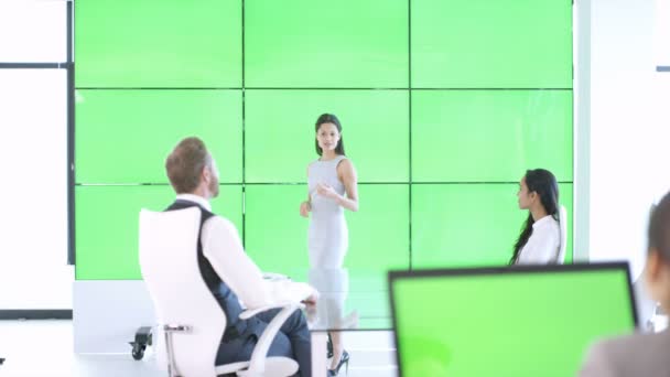 年轻的女实业家展示和互动与绿色屏幕视频墙 — 图库视频影像