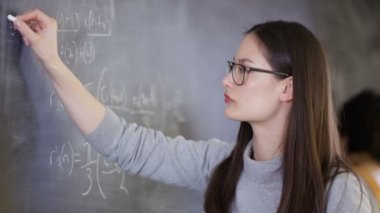 yazı tahtası üzerinde matematiksel Denklem yazma 4 k genç akıllı üniversite öğrencisi