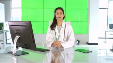 Müşteri veya hasta için yeşil arka plan üzerinde konuşurken 4 k mutlu tıbbi hizmet danışmanı