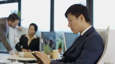 4 k endişeli işadamı bilgisayar tablet kullanma ve meslektaşları konuşmak Office