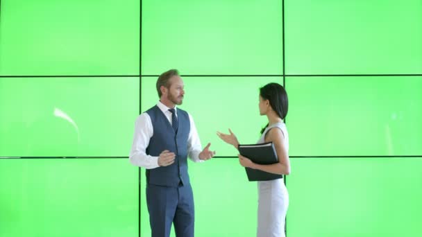 ビジネスの男性と女性の緑色の画面で近代的なオフィスに書類を議論します — ストック動画
