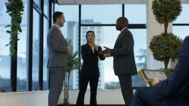 4 k karışık etnik köken iş grubu ayakta pencere ve şehir ofiste sohbet