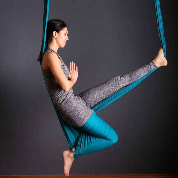 Ung vacker brunett kvinna gör flyga yoga. Sitter i hängmattan — Stockfoto