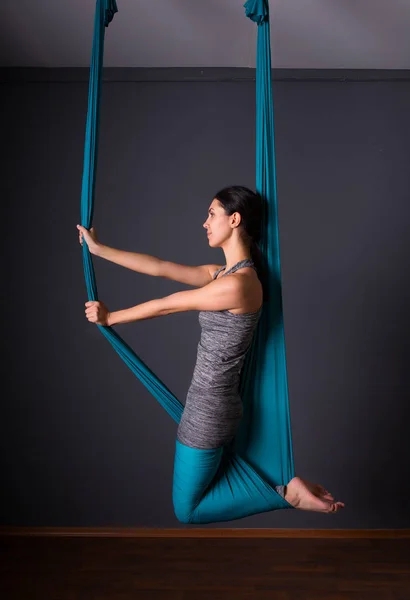 Jonge mooie brunette vrouw vliegen yoga doen. Vergadering in hammoc — Stockfoto