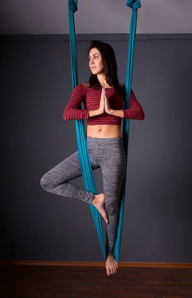 Ung vacker brunett kvinna gör flyga yoga. Sitter i hängmattan — Stockfoto