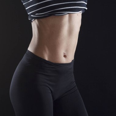 Güzel vücut geliştirmeci kadının karın üzerinde siyah backg portresi