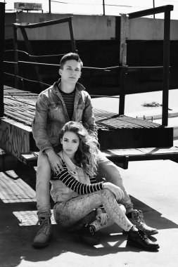 Genç güzel çift giyen kot giysiler ışığında moda.