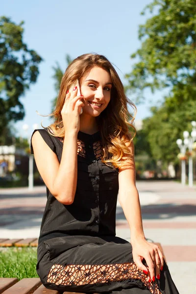 Portret van een jonge lachende mooie vrouw praten over de telefoon — Stockfoto