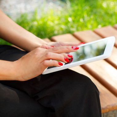 Kadın parkta oturan tablet boş ekran dokunaklı