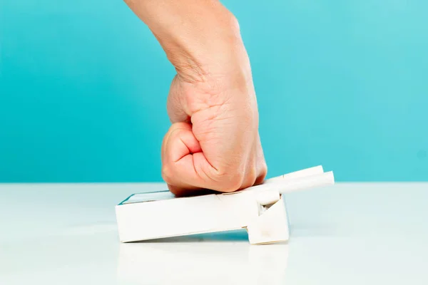 Man's hand crushing cigarettes over blue background. Stop smokin — Stock Photo, Image