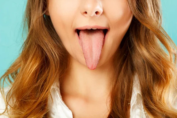 Close up of healthy woman tongue over blue background — Stock Photo, Image