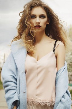 Genç güzel sarışın kadın mavi ceket açık havada poz