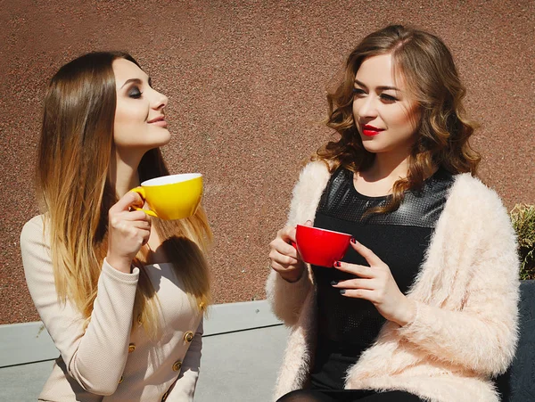 Dos jóvenes bastante feliz mujer sentada al aire libre y beber café — Foto de Stock