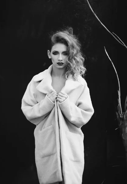 Young beautiful blonde woman posing in coat outdoors — Stock Photo, Image