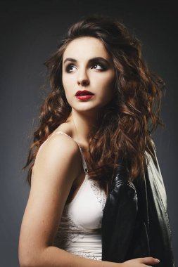 Güzel genç kadın deri ceketle üzerinde gri backgro poz