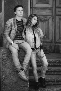 Genç güzel çift giyen kot giysiler ışığında moda.