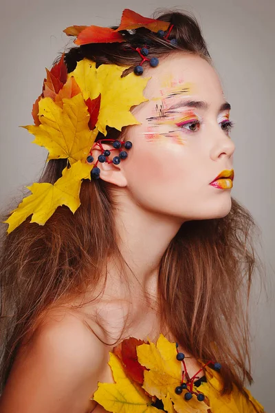 Joven mujer hermosa con maquillaje de otoño y hojas en la cabeza. Sé — Foto de Stock