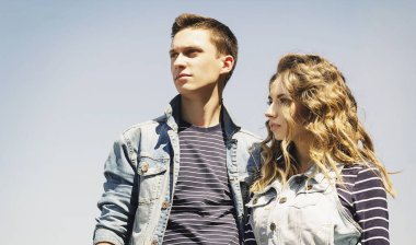 Genç güzel çift giyen kot giysiler ışığında moda.