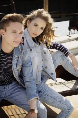 Genç güzel çift giyen kot giysiler ışığında moda.