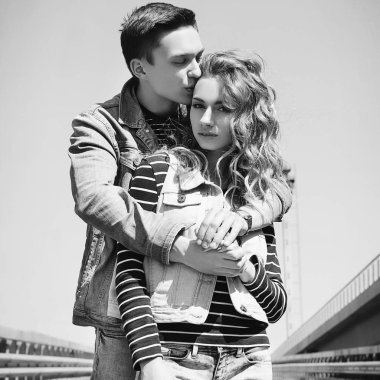 Genç güzel çift giyen kot giysiler ışığında moda.