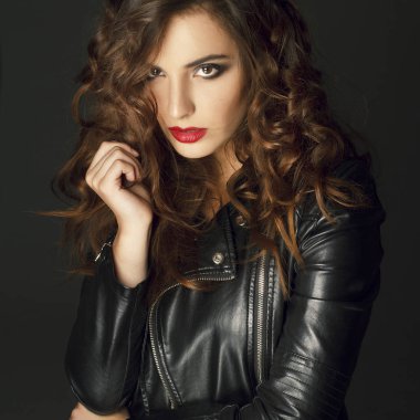 Siyah deri ceket gri b üzerinde poz güzel genç kadın