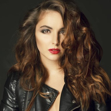 Siyah deri ceket gri b üzerinde poz güzel genç kadın