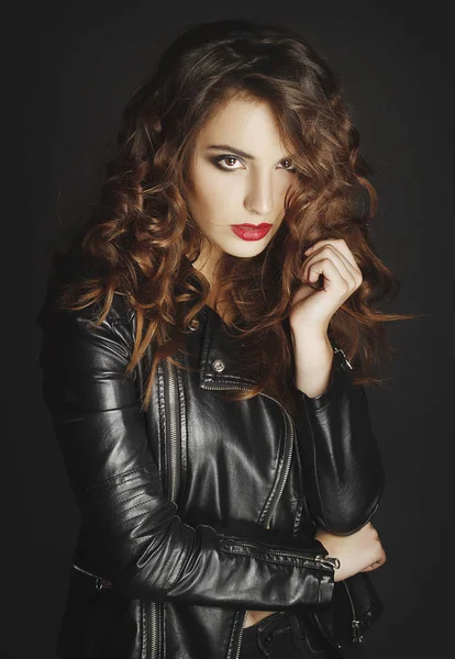 Siyah deri ceket gri b üzerinde poz güzel genç kadın