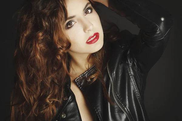 Siyah deri ceket gri b üzerinde poz güzel genç kadın