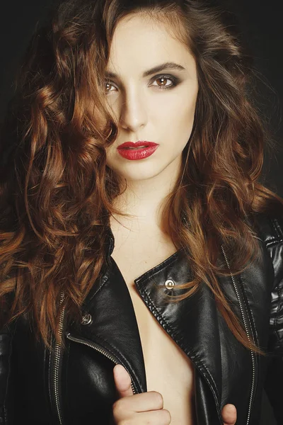Siyah deri ceket gri b üzerinde poz güzel genç kadın