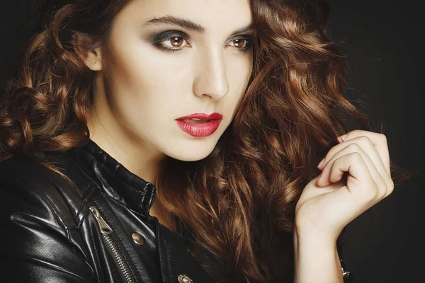 Siyah deri ceket gri b üzerinde poz güzel genç kadın