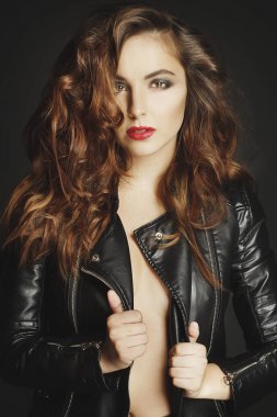 Siyah deri ceket gri b üzerinde poz güzel genç kadın