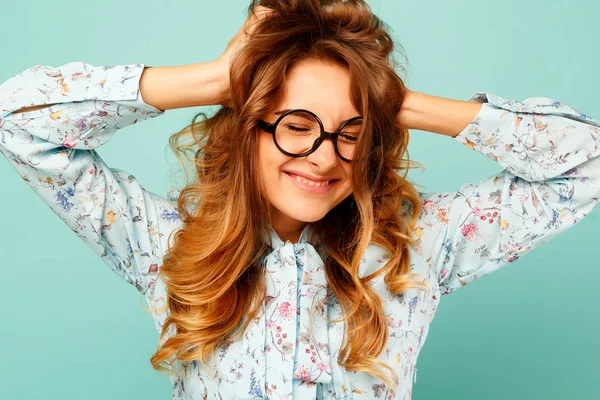 Mooie smiley meisje met bril op blauwe achtergrond — Stockfoto