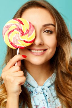 Lolipop üzerinde mavi ba elinde tutan gülen kadın genç güzel