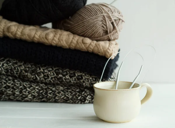 Imagen de suéteres acogedores y taza de café o té sobre bac blanco —  Fotos de Stock