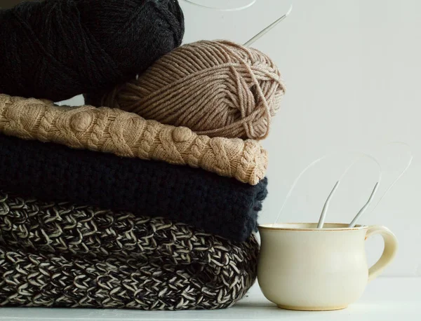 Imagen de suéteres acogedores y taza de café o té sobre bac blanco —  Fotos de Stock