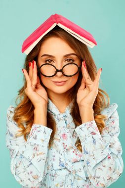 Güzel genç öğrenci kitap üstünde onun baş ve giyen gla